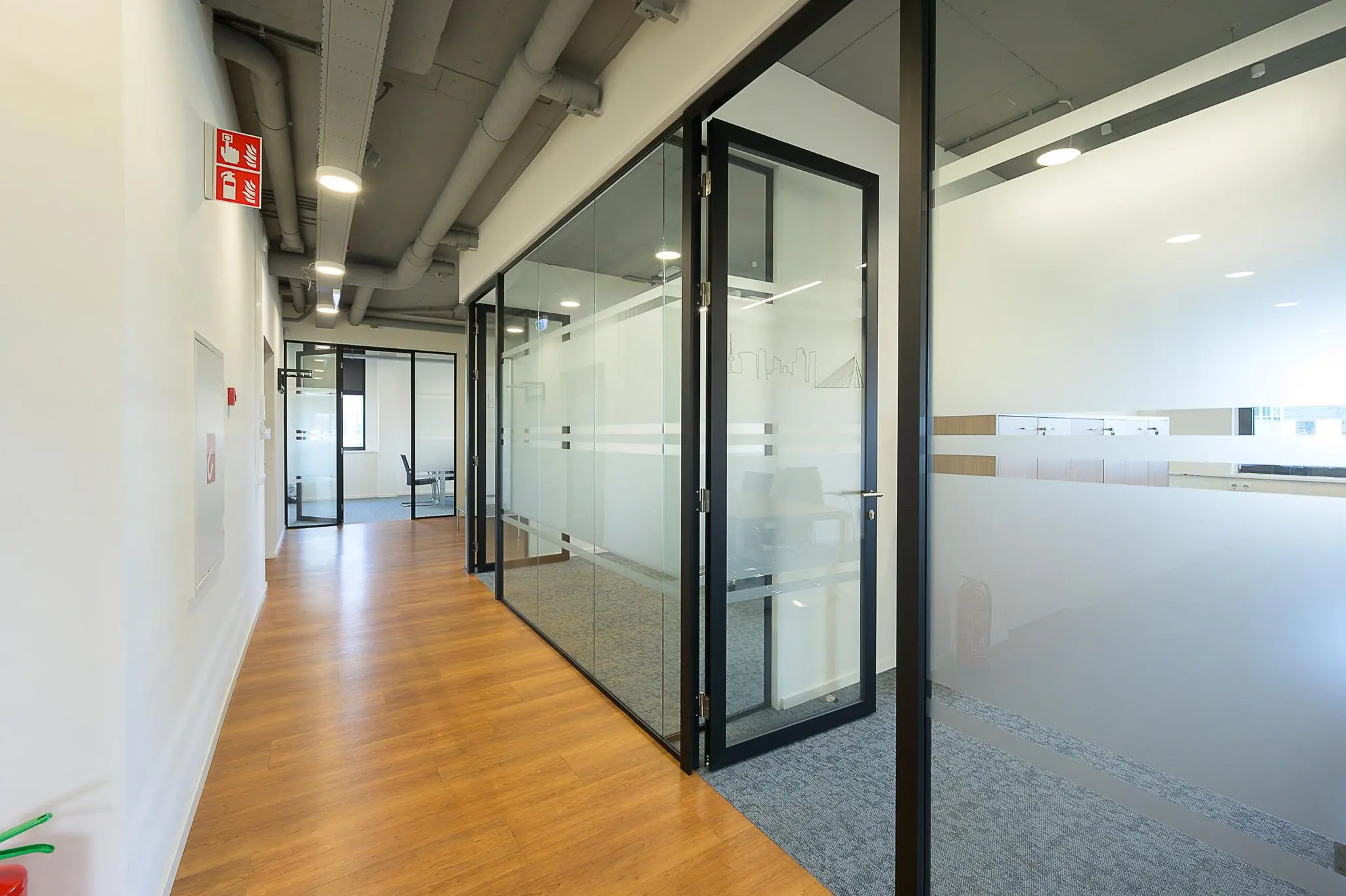 Moderne kantoorruimte aan de K.P. van der Mandelelaan met glazen vergaderruimtes en houten vloer.